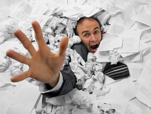 Businessman sinking in heap of documents — Stock Photo, Image
