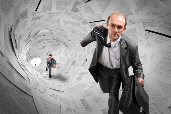 Empresarios corriendo dentro del túnel de documentos — Foto de Stock