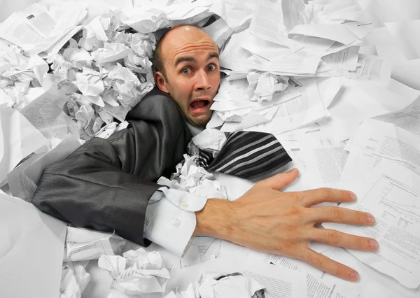 Homme d'affaires coulant dans un tas de documents — Photo