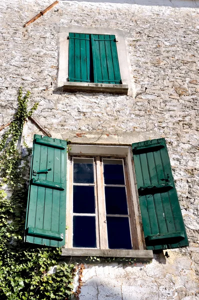 Antigua fachada con ventanas con persianas verdes —  Fotos de Stock