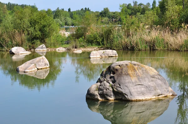 Kamienie rozrzucone wokół jeziora — Zdjęcie stockowe