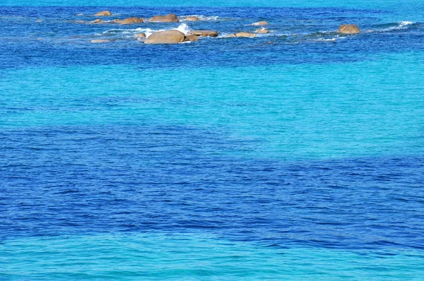 Vallende stenen in de turquoise zee — Stockfoto