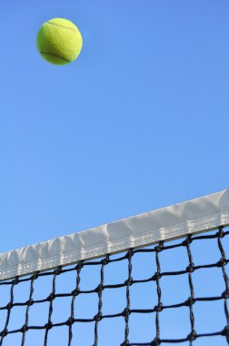 net üzerinden uçan sarı tenis topu