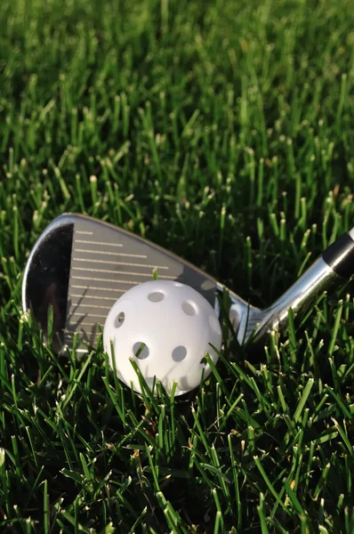 Vit plast wiffle bollen och golf club — Stockfoto