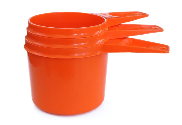 Três copos de medição de plástico laranja — Fotografia de Stock