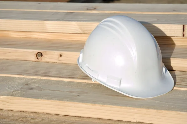 木材に白いハード帽子 — ストック写真