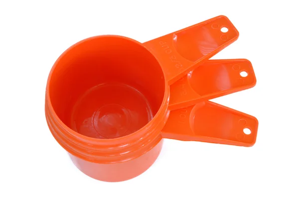 Drei orangefarbene Messbecher aus Kunststoff — Stockfoto