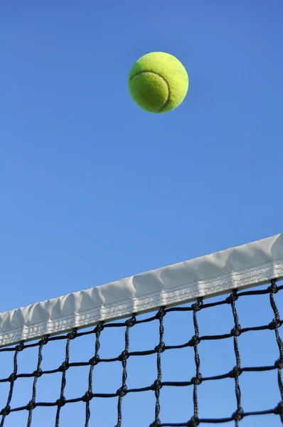 Yellow Tennis Ball Flying Over the Net — Stock Photo, Image