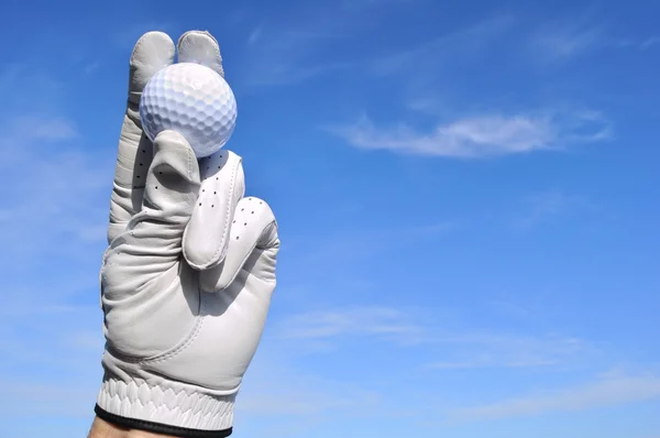 Golfspelare håller en golfboll — Stockfoto