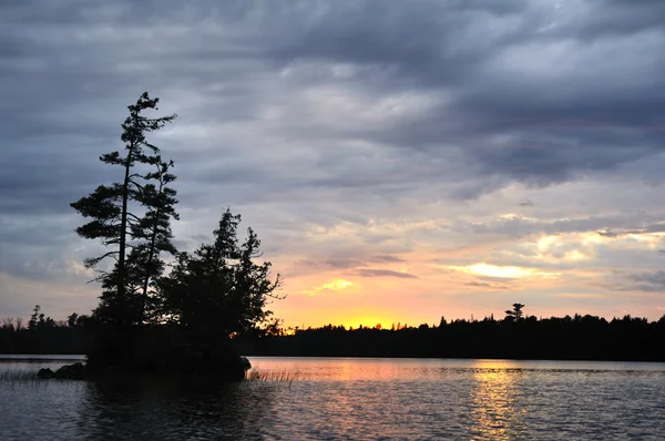 Natursköna ön på en avlägsen vildmark sjö vid solnedgången — Stockfoto