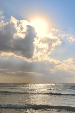 Sunbeams Trough the Clouds Above the Ocean clipart