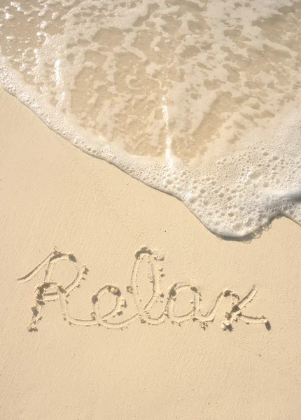 Kum plajı üzerinde yazılı rahatla — Stok fotoğraf