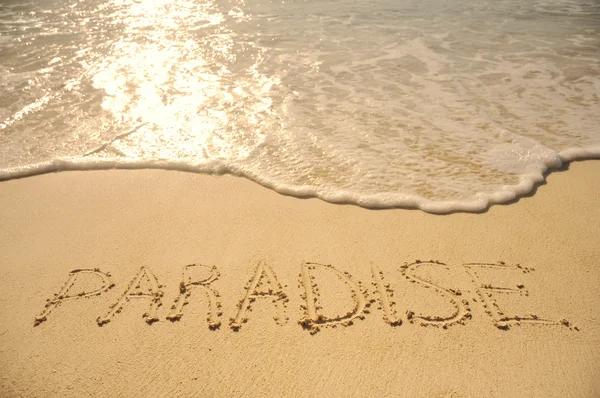 Kum plajı üzerinde yazılı cennet — Stok fotoğraf