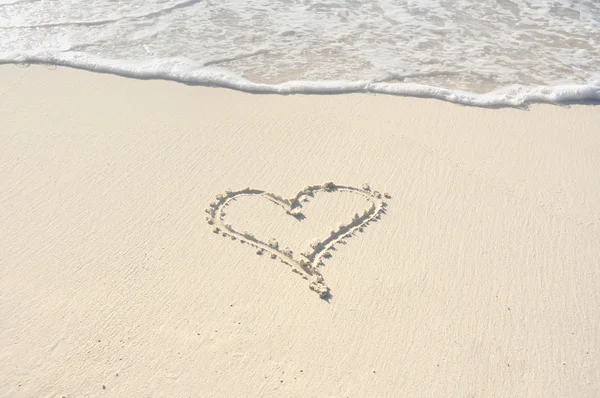 Srdce zakresleny v písku na pláži — Stock fotografie