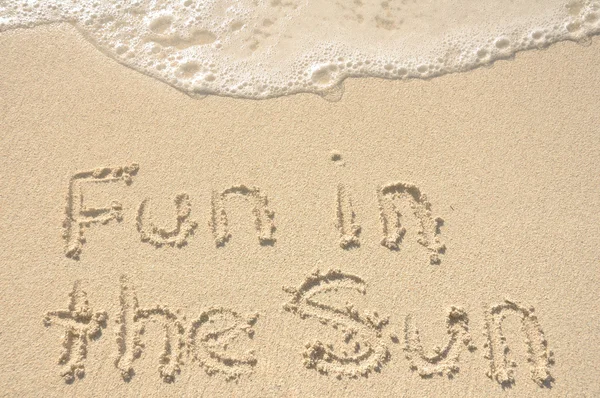 Divertimento al sole Scritto in sabbia sulla spiaggia — Foto Stock