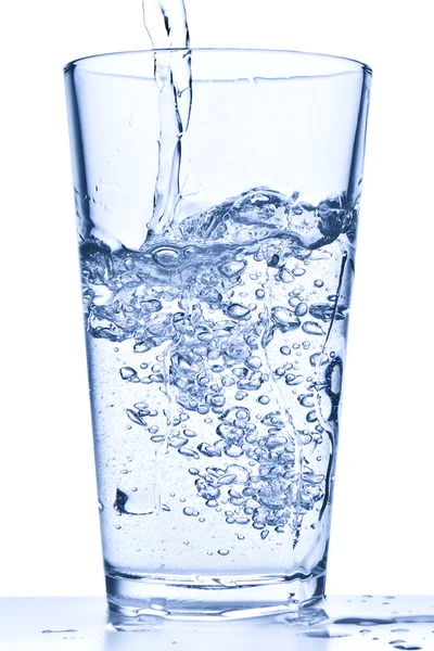 Наливаємо воду в склянку — стокове фото