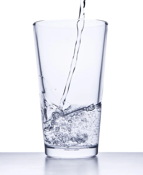 Наливаємо воду в склянку — стокове фото