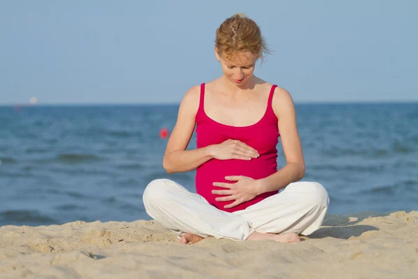 Hermosa mujer embarazada en una playa — Foto de Stock