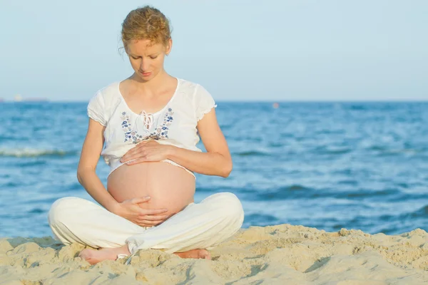 Gravid kvinna på strand Royaltyfria Stockbilder