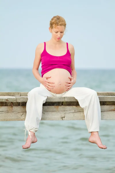 Gravid kvinna på strand Royaltyfria Stockbilder