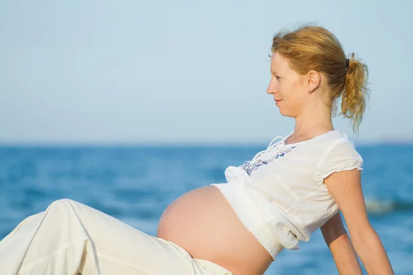 Gravid kvinna på strand Stockbild