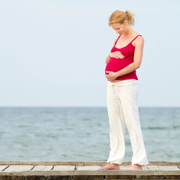 Gravid kvinna på strand Royaltyfria Stockfoton