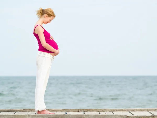 Gravid kvinna på strand Royaltyfria Stockfoton