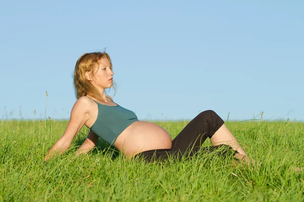Femme enceinte sur prairie — Photo