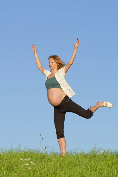 Беременная женщина на лугу — стоковое фото