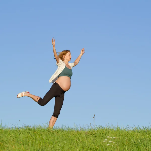 Hamile kadın üzerinde çayır — Stok fotoğraf
