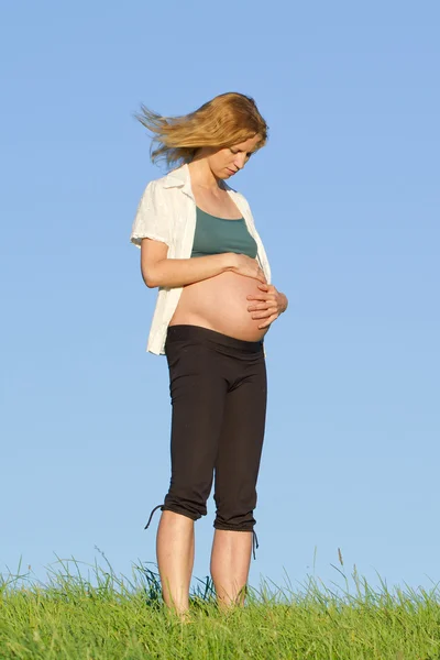 Femme enceinte sur prairie — Photo