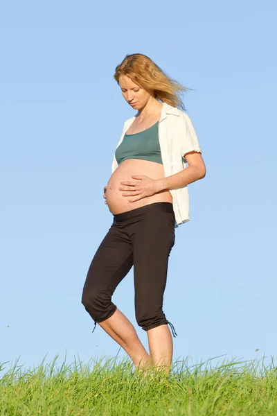 Pregnant woman on meadow — Stock Photo, Image
