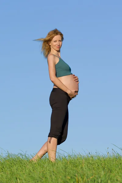 Gravid kvinne på engen – stockfoto