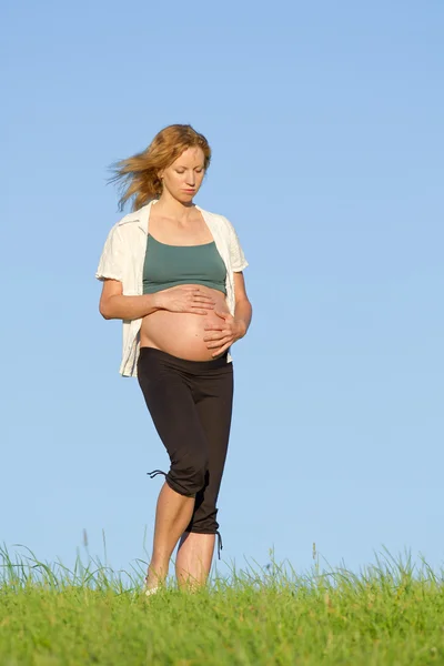 Mujer embarazada en el prado — Foto de Stock