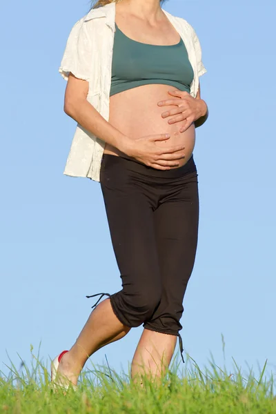 Těhotná žena na louce — Stock fotografie