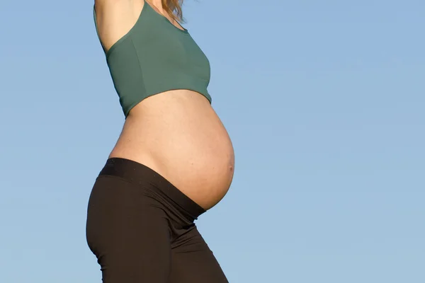 Беременная женщина на лугу — стоковое фото