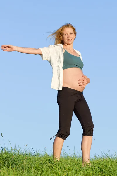 Pregnant woman on meadow Stock Image