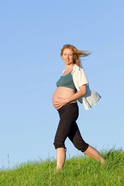 Pregnant woman on meadow Stock Image