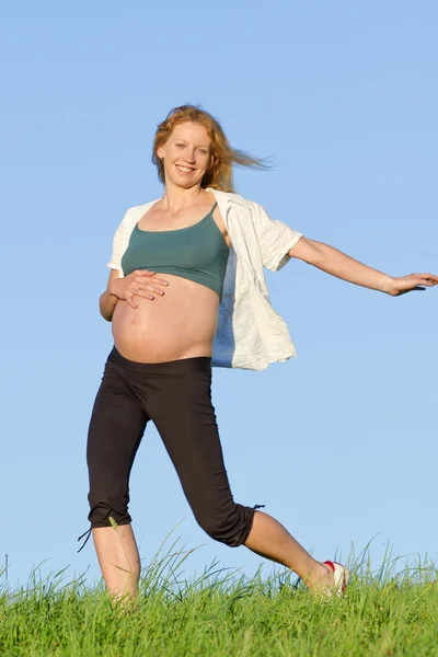 Pregnant woman on meadow Royalty Free Stock Photos