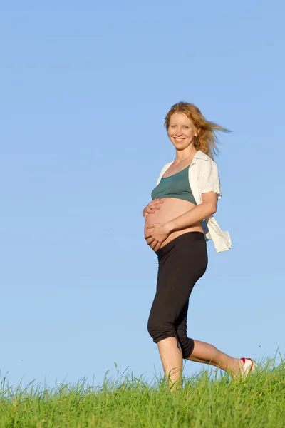 Pregnant woman on meadow Royalty Free Stock Images