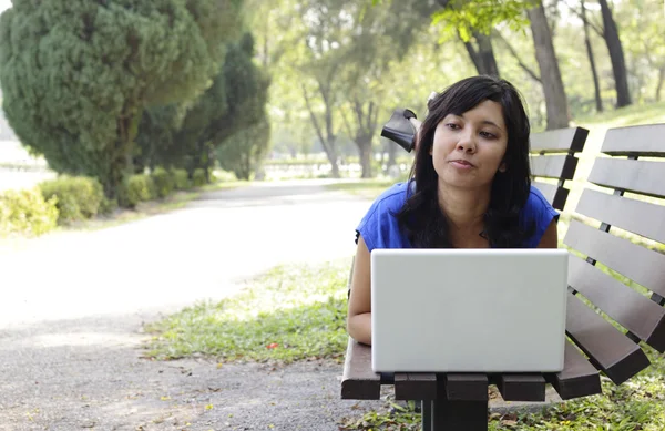 Женщина с ноутбуком в парке — стоковое фото