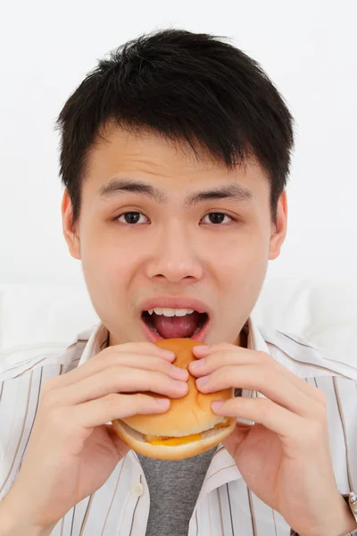 Hombre comiendo hamburguesa Imagen de archivo