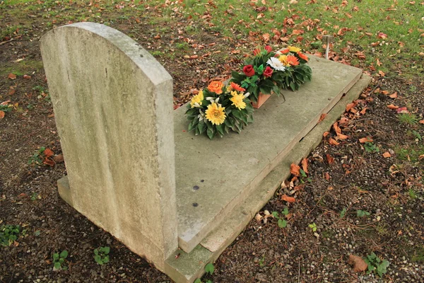 Tombstone with flowers — Stock Photo, Image