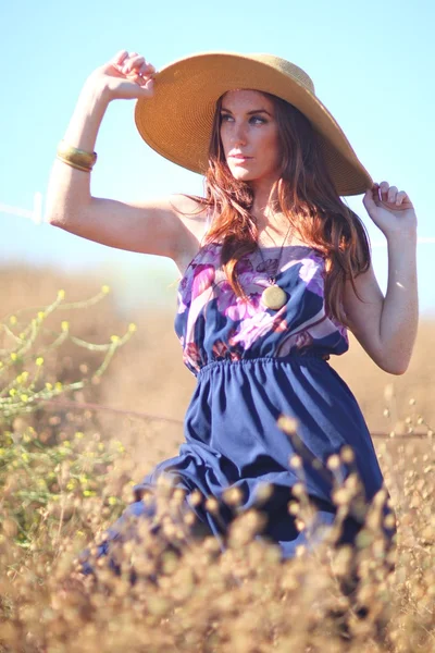 Joven hermosa mujer en un campo en la hora de verano — Foto de Stock