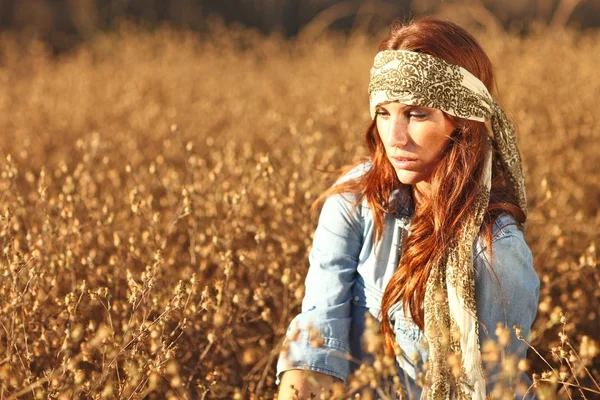 Mooie vrouw op een veld in de zomer — Stockfoto