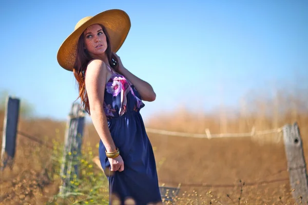 Jonge mooie vrouw op een veld in de zomer — Stockfoto