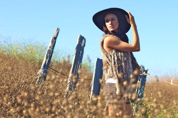 Unga vackra kvinnan på ett fält i sommartid — Stockfoto