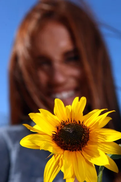Rood donkerharige vrouw buiten in een zonnebloem veld — Stockfoto
