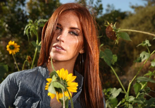 Червоні волосся жінка на відкритому повітрі в поле соняшникова — стокове фото