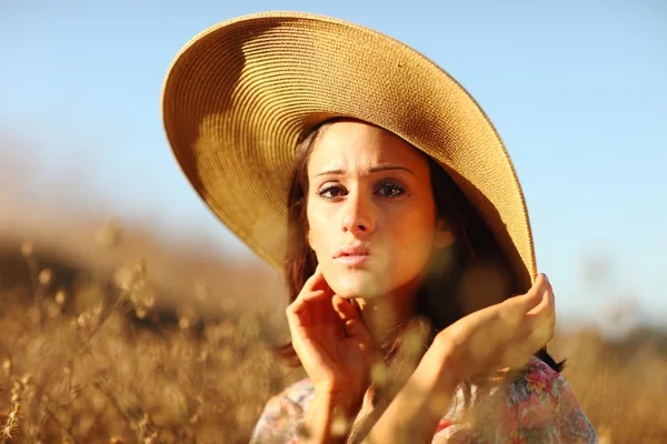 Unga vackra kvinnan på ett fält i sommartid — Stockfoto